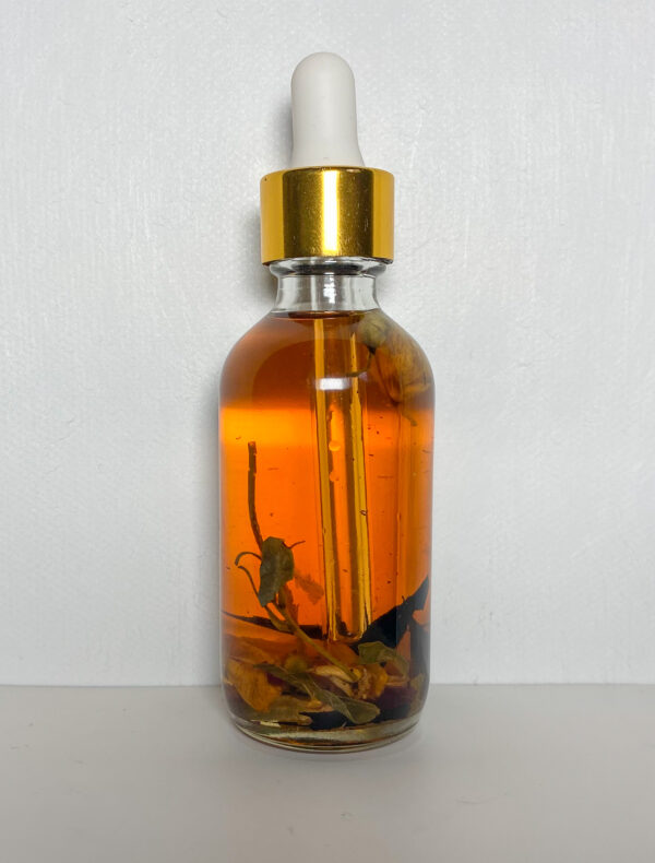 A bottle of oil with some flowers on it