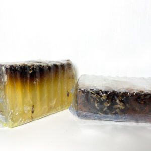 Two soap bars wrapped in plastic and sitting on top of a table.